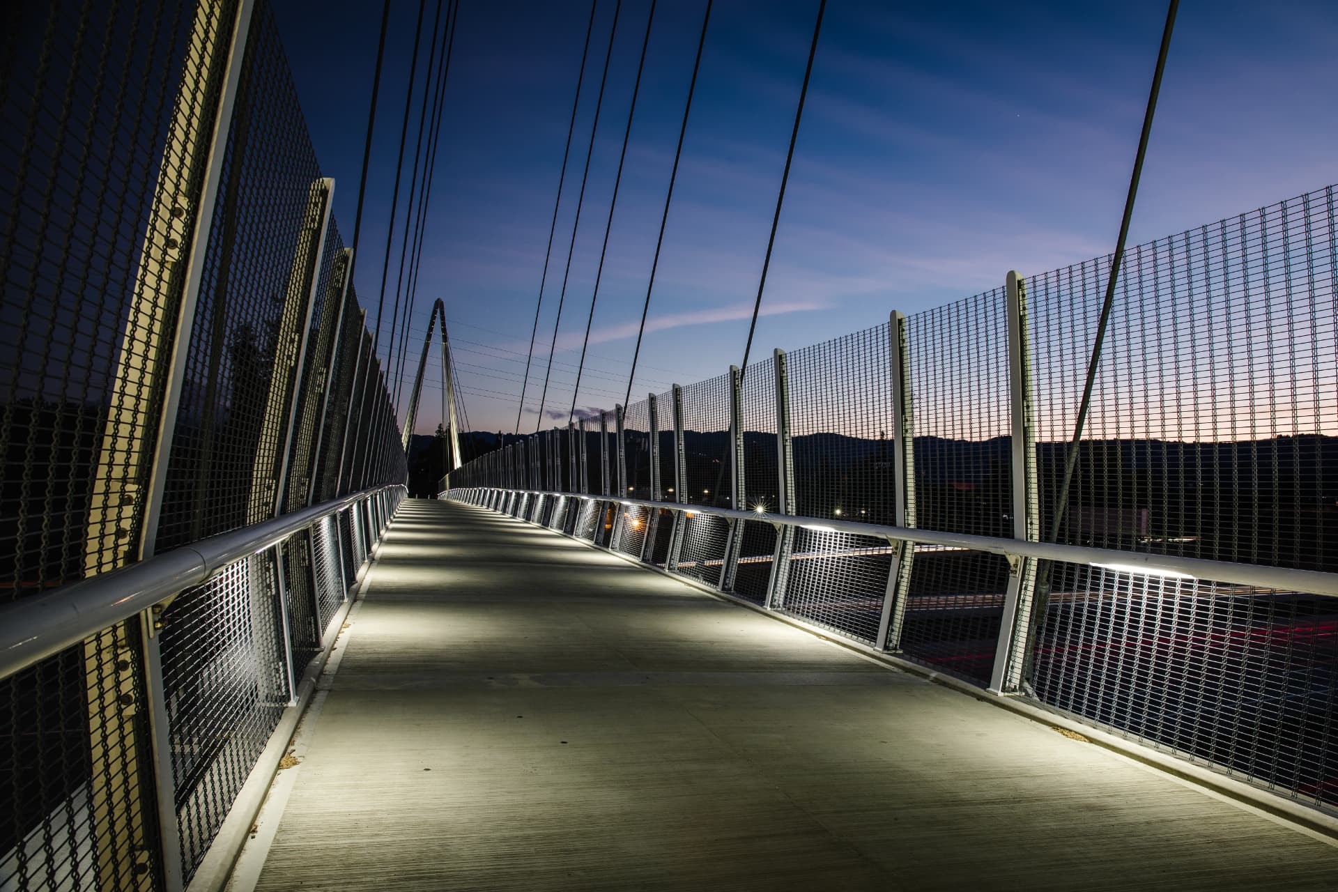 Illuminated pedestrian bridge at dusk